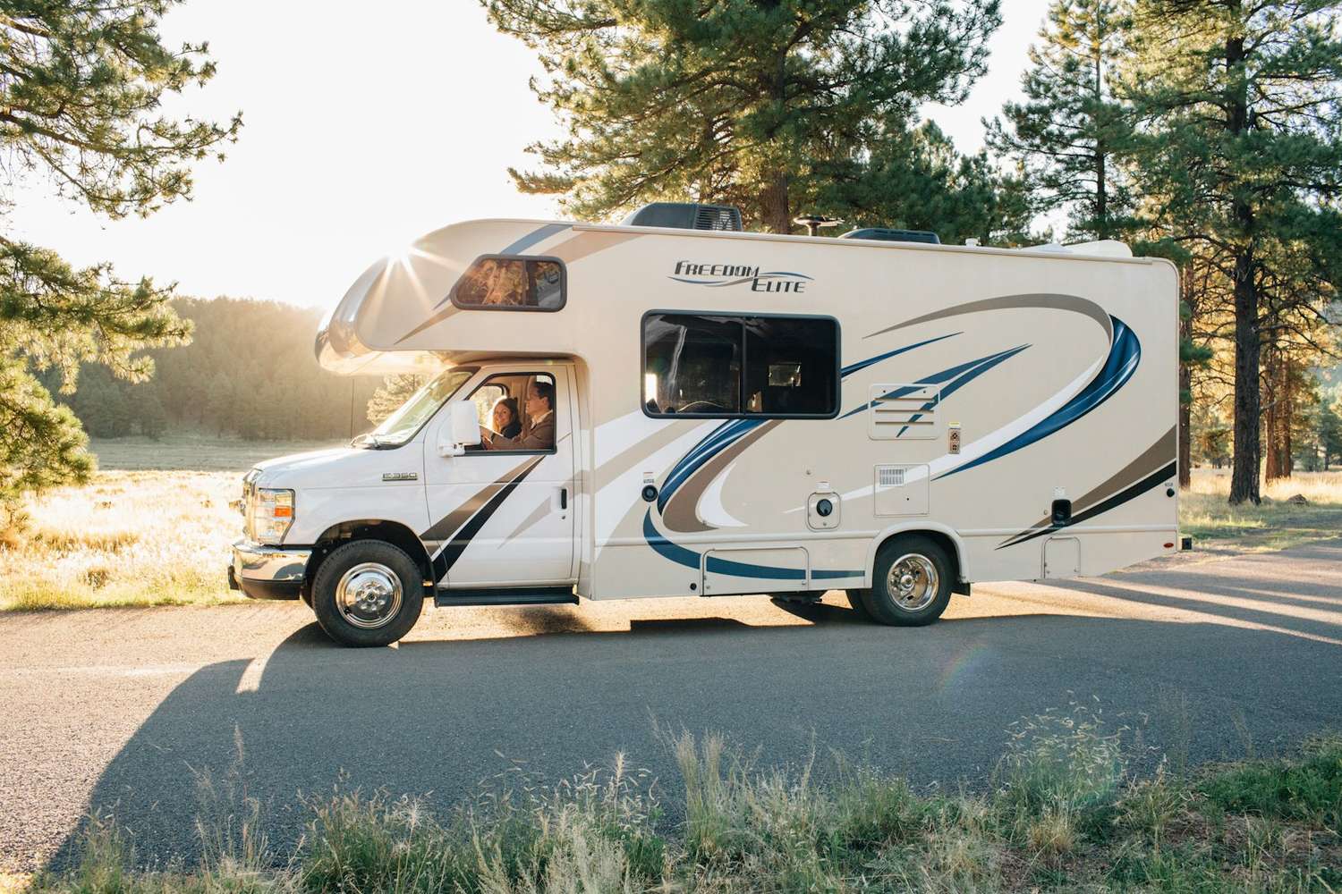 A motorhome parked on a forest road at golden hour